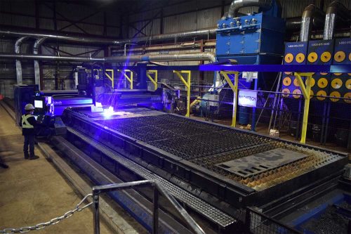 a CNC cutting machine inside a custom fabrication shop