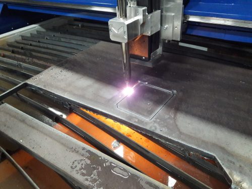 close up of plasma torch processing steel plate on a CNC cutting table