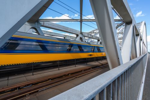steel railroad bridge with train speeding by